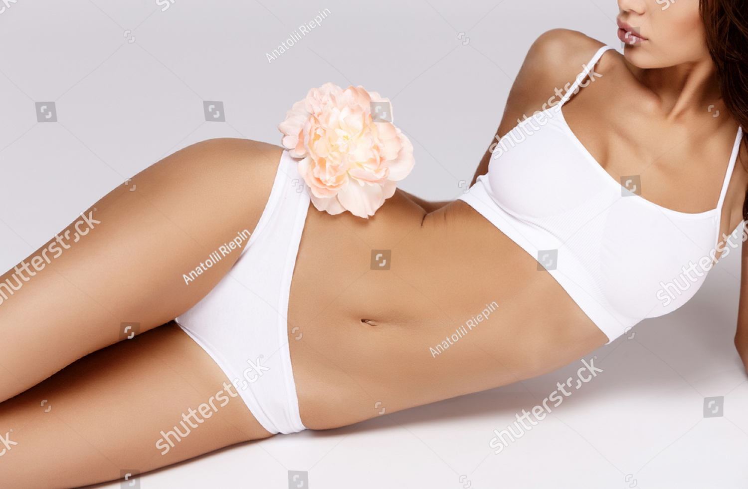 stock-photo-slim-tanned-woman-s-body-over-gray-background-401725924